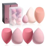 A set of seven pink makeup sponges in various shapes, including one mini, neatly arranged in an open gradient pink storage ca