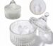 Two white velour body powder puffs with bows inside a clear crystal glass container on a white background