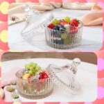 Two white velour body powder puffs with bows inside a clear crystal glass container on a white background