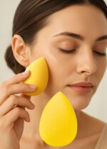 Three yellow teardrop-shaped makeup sponge blenders on a clean surface, ready for foundation application.