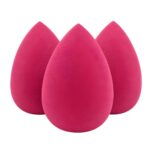 Three yellow teardrop-shaped makeup sponge blenders on a clean surface, ready for foundation application.