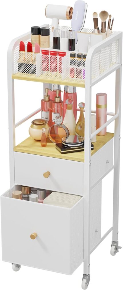 White and wood rolling makeup organizer cart with divided top, open shelf, and two fabric drawers, filled with cosmetics.